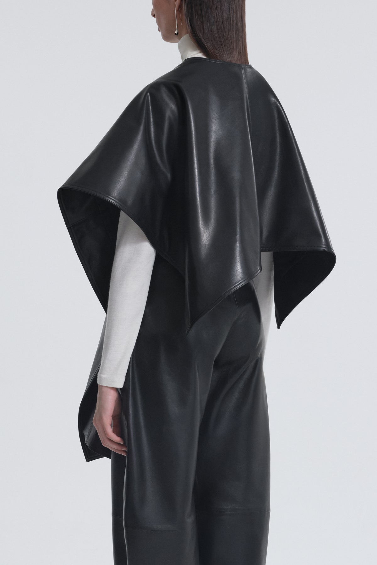 Model is Wearing Nour Hammour Edra Sleek Leather Cape Black - Three Quarters 
