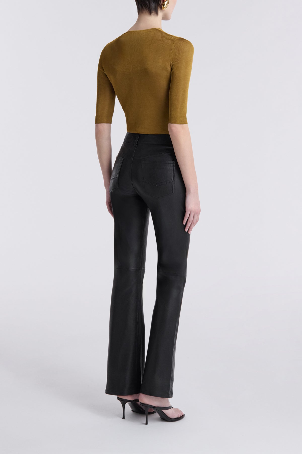Model is Wearing the Nour Hammour Flare Stretch Leather Pants Black - Back